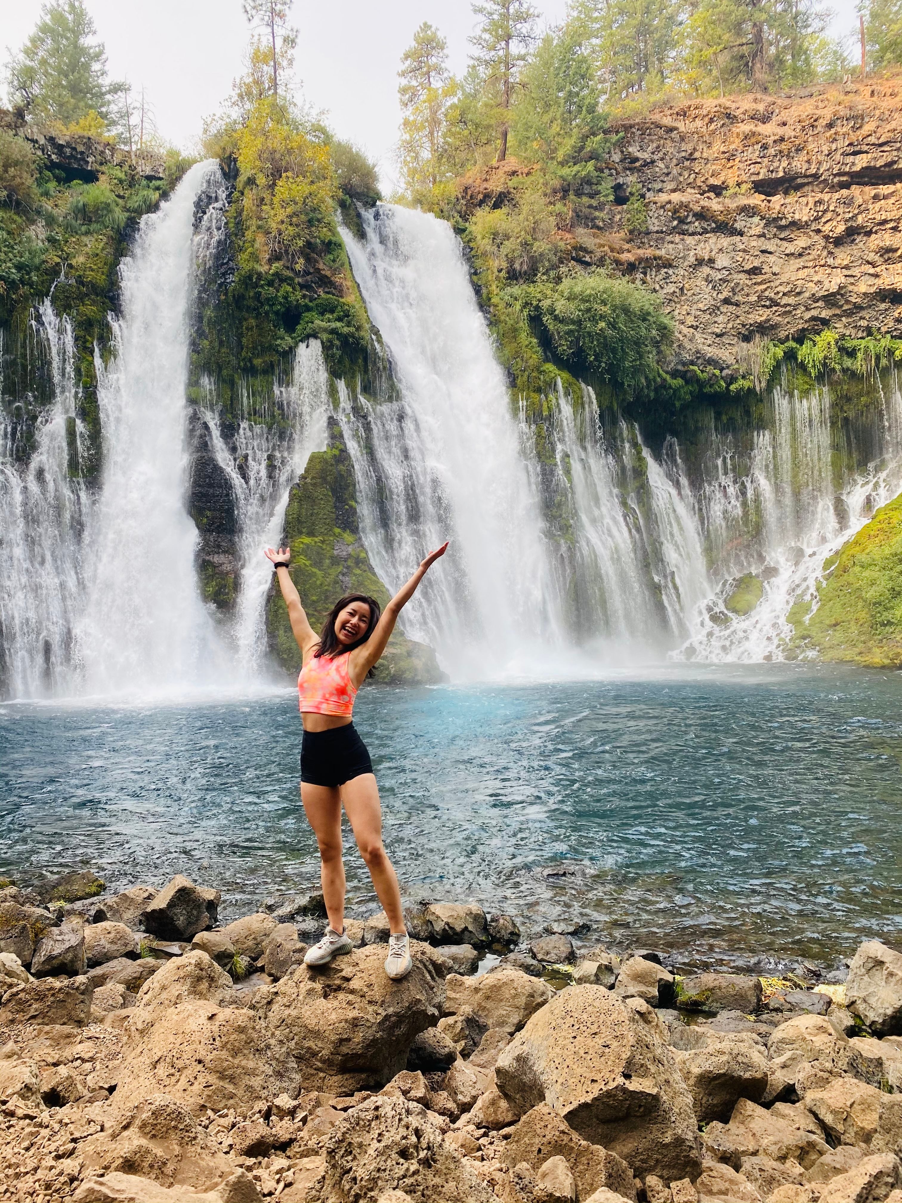 Longevity Coach at waterfall showing active lifestyle